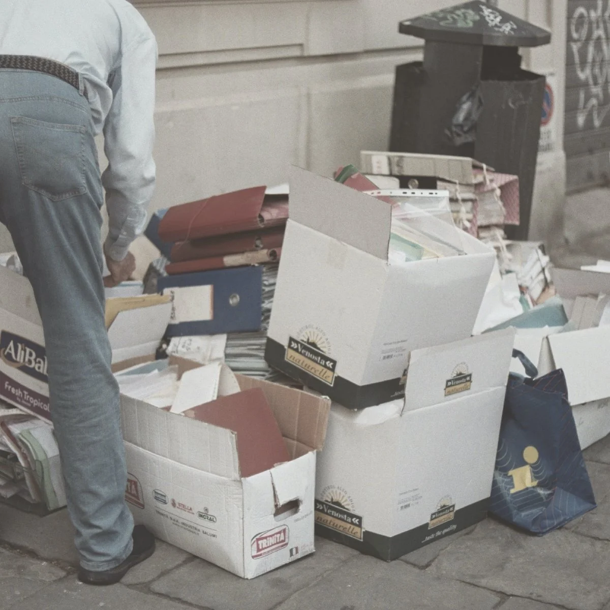 Person sorting through boxes of disorganized paperwork