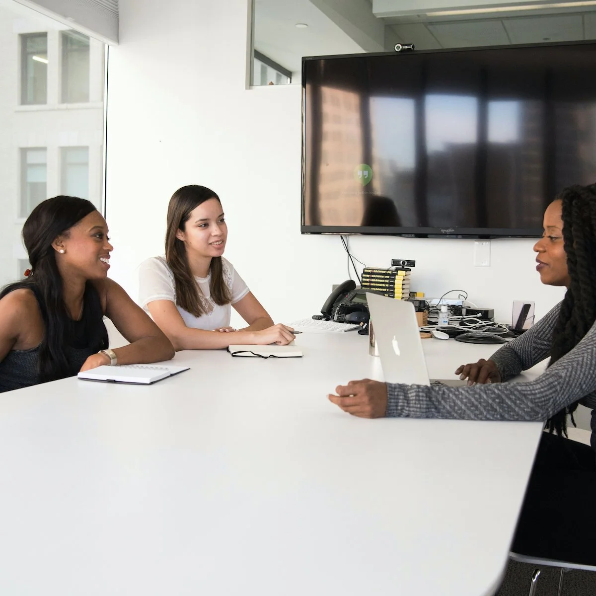 Three colleagues meeting around a conference table
